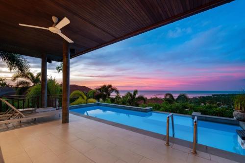 a villa with a swimming pool and a sunset at Villa Baan Saitara in Lamai