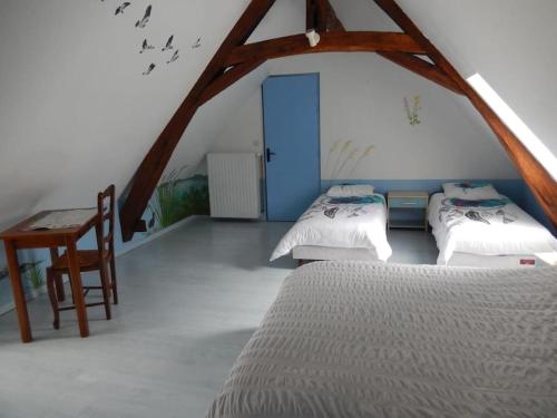 Charnizay的住宿－Gite à la ferme 15 personnes avec jacuzzi，一间卧室设有三张床、一张桌子和一扇蓝色的门