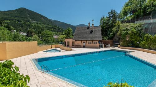a swimming pool in a yard with a house at Vacancéole - Résidence Les Gorges Rouges in Guillaumes