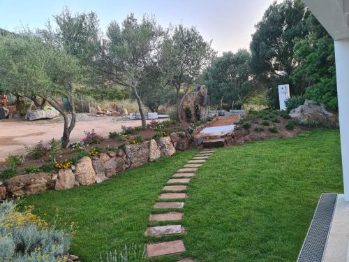 un giardino con sentiero in pietra e panca di Sea & Country Rooms a Golfo Aranci