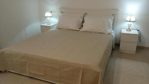 a bedroom with a large bed with two night stands at Sea & Country Rooms in Golfo Aranci