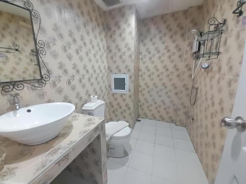 a bathroom with a sink and a toilet and a mirror at ณ บ้านแม่ รีสอร์ท in Ban Rai