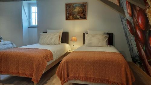two beds sitting next to each other in a room at L'Ostal de Gagnac in Gagnac-sur-Cère