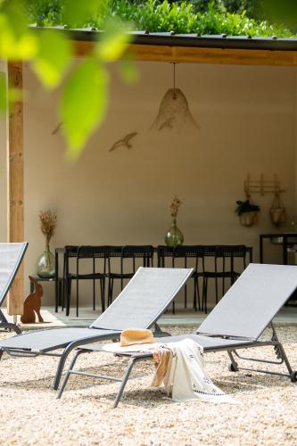 two lounge chairs on a beach with a table at Le Moulin de la Maison des Templiers in Saint-Cernin-de-Larche