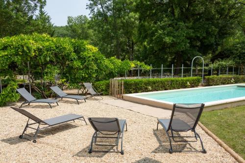 a group of chairs and a swimming pool at Le Moulin de la Maison des Templiers in Saint-Cernin-de-Larche