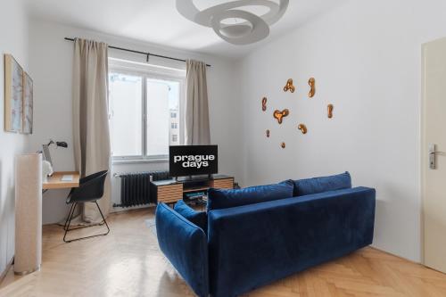 a living room with a blue couch and a desk at Contemporary Flat in New Town by Prague Days in Prague