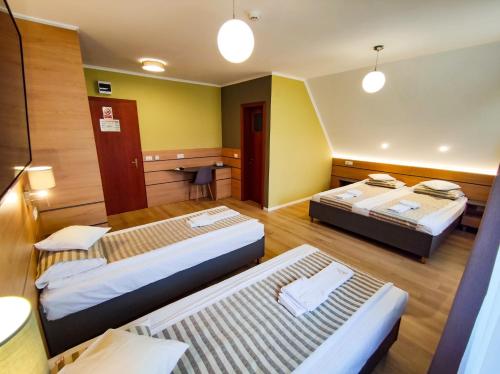 a hotel room with two beds in a room at Bonanza Pensiune & Restaurant in Cluj-Napoca