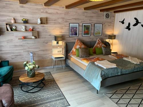 - une chambre avec un lit et un mur en bois dans l'établissement Moselina Gästezimmer, à Sankt Aldegund