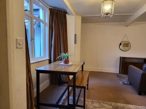 a living room with a table with a plant on it at Seaside Flat with Fast WiFi in Scarborough