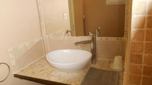 uma casa de banho com um grande lavatório branco no chuveiro em Agréable studio près de st Rémy de Provence em Eyragues