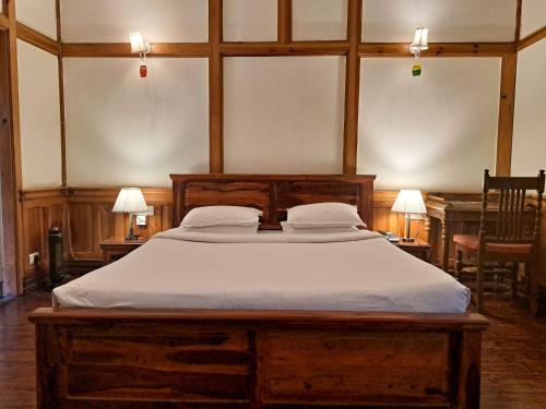 a bedroom with a large bed with white sheets at The Heritage Club - Tripura Castle Hotel and Spa in Shillong