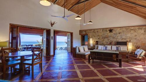 una sala de estar con una pared de piedra y una mesa. en Superbe villa avec ponton privé, en Andilana