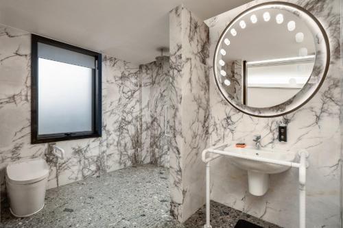 a bathroom with a sink and a mirror at Hotel Indigo Guangzhou Haixinsha by IHG - Free Shuttle Bus to Canton Fair Complex during Canton Fair period in Guangzhou