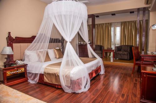 1 dormitorio con 1 cama con mosquitera en Best Western Plus Paramount Hotel, en Lusaka