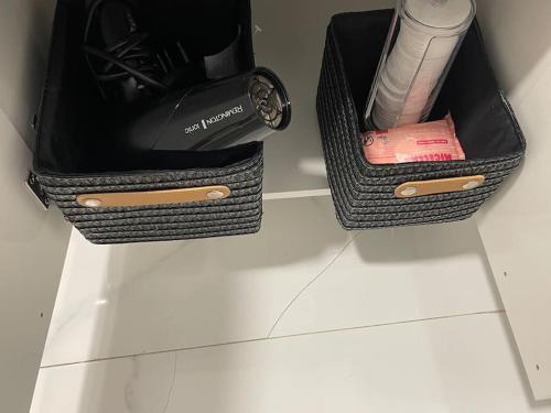 two black baskets sitting on a white counter with a hair dryer at Casa Luna IV tu oasis en Madrid in Madrid