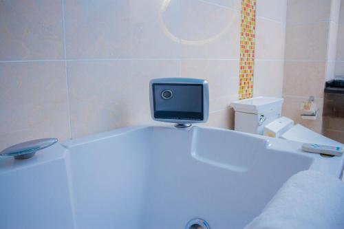 a bathroom with a tv sitting on top of a tub at Best Western Plus Paramount Hotel in Lusaka