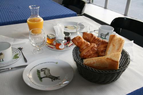 een tafel met een mand met brood en jus d'orange bij La Maison Normande in Trouville-sur-Mer