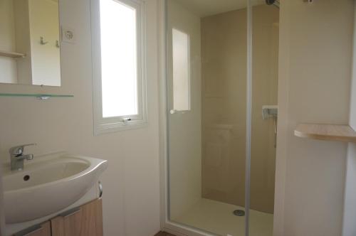 a bathroom with a sink and a glass shower at Camping de l'île in Bannay