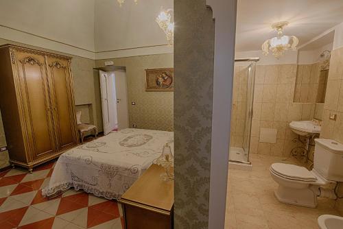 a bedroom with a bed and a bathroom with a toilet at Palazzo Tilli in Casoli