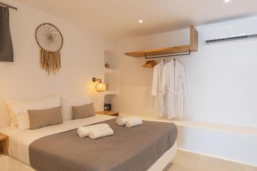a bedroom with a bed with two towels on it at Sunset Hill Suites in Mýkonos City