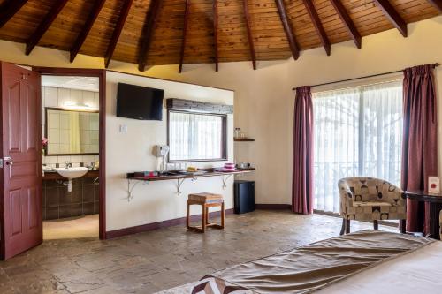 a bedroom with a bed and a sink in a room at Sentrim Elementaita Lodge in Elmenteita