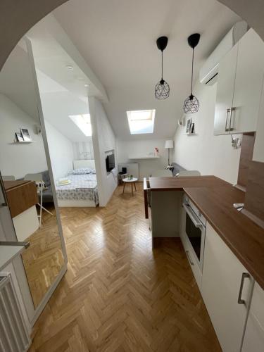 Una cocina y una sala de estar con una cama al fondo. en STELLA Appartment, en Novi Sad