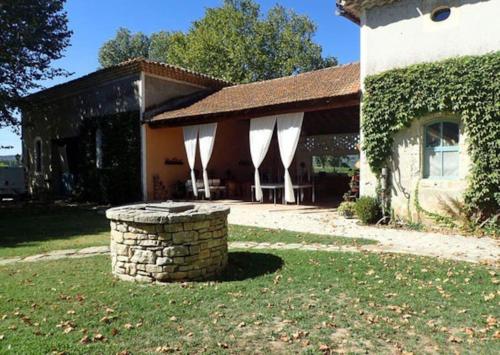 une maison avec un pilier en pierre dans la cour dans l'établissement Davaï appartement 6 personnes, à Pont-Saint-Esprit