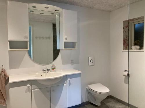 a white bathroom with a sink and a toilet at Perlan in Sørvágur