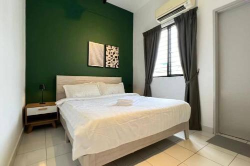 a bedroom with a large bed with a green wall at Spacious Townvilla - 10pax in Puchong