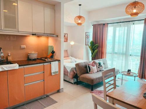 een keuken en een woonkamer met een bed bij Studio Unit Viceroy Residences McKinley Hill BGC in Manilla
