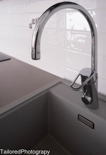 a kitchen sink with a faucet over it at Uusi asunto ydinkeskustassa, Wifi, ilmainen pysäköinti in Lappeenranta
