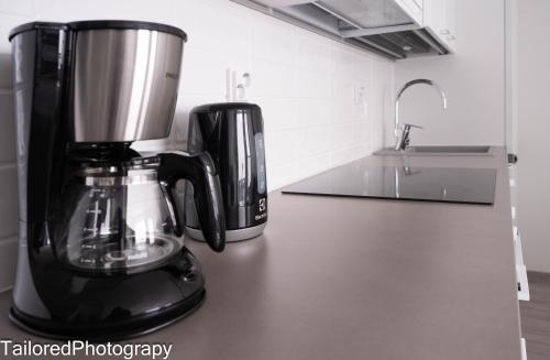 a black coffee maker sitting on a counter at Uusi asunto ydinkeskustassa, Wifi, ilmainen pysäköinti in Lappeenranta