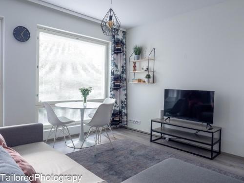 a living room with a table and a tv at Uusi asunto ydinkeskustassa, Wifi, ilmainen pysäköinti in Lappeenranta