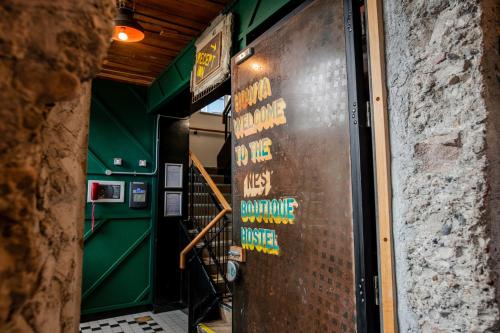 een metalen deur met borden aan de zijkant van een gebouw bij The Nest Boutique Hostel in Galway