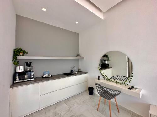a kitchen with a table and a mirror and a chair at Sea Horizon Vsl Suites & Apartments in Sarandë