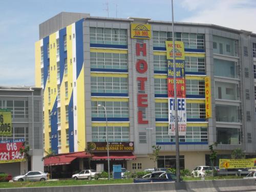 un grand bâtiment avec des panneaux devant lui dans l'établissement Sun Inns Hotel Puchong, à Puchong