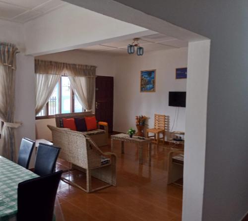 een woonkamer met een tafel en stoelen bij Landa's Guest House in Praia do Tofo