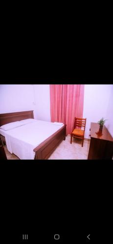 ein Schlafzimmer mit einem Bett, einem Stuhl und einem Fenster in der Unterkunft Kazua Homestay in Daressalam