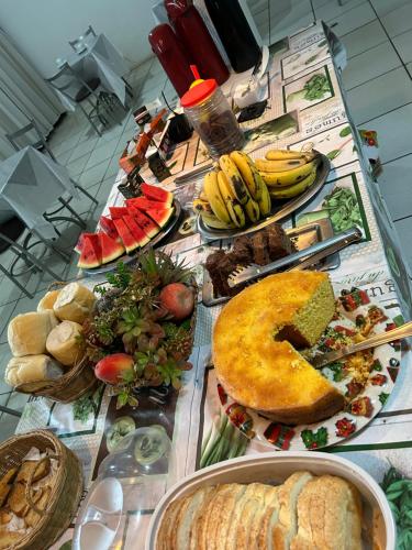 a table topped with lots of different types of food at Aloys Hotel in Cascavel
