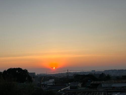 a sunset over a city with the sun in the sky at Aloys Hotel in Cascavel