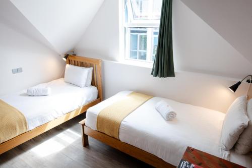 a bedroom with two beds and a window at The Nest Boutique Hostel in Galway