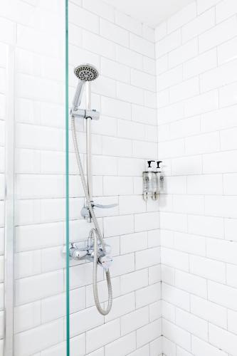 a shower with a shower head in a bathroom at The Nest Boutique Hostel in Galway