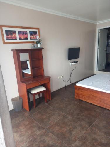 a bedroom with a bed and a desk and a mirror at Germaroze in Oslob