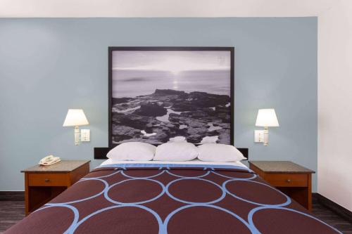 a bedroom with a bed with a large picture on the wall at Super 8 by Wyndham El Cajon San Diego in El Cajon