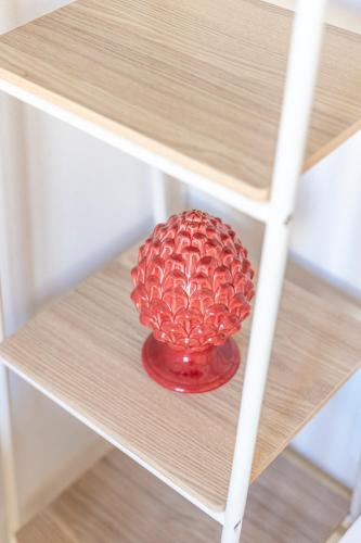 a red vase sitting on a wooden table at LE CASE DEL FICO D'INDIA FAVIGNANA in Favignana