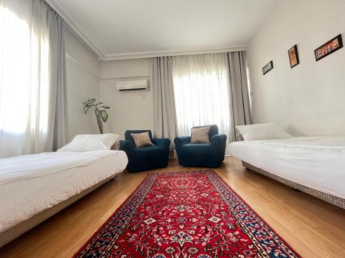 - un salon avec 2 lits et un tapis rouge dans l'établissement Large and Simple Family House in Antalya Center, à Antalya