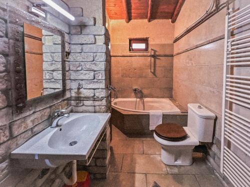 a bathroom with a sink and a toilet and a tub at The Little Stone House by the Lake in Kastoria