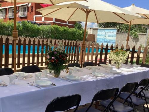 a white table with chairs and an umbrella at Villa ChezSoa, Antananarivo in Antananarivo