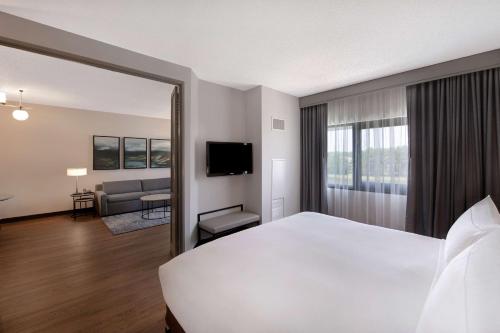 a hotel room with a large bed and a living room at DoubleTree Suites by Hilton Raleigh-Durham in Durham