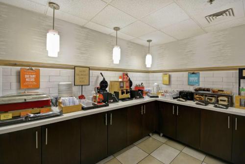 a kitchen with a long counter with cabinets and a unintention at Hampton Inn Detroit Madison Heights South Troy in Madison Heights